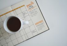 2025년, 새해의 건강 목표를 세우는 법 white ceramic mug with coffee on top of a planner