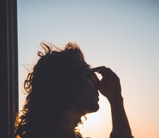 스트레스 관리와 운동의 관계 man holding forehead under sunset