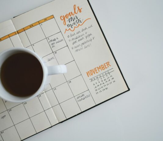 생산성 향상의 열쇠가 되는 직장 내 스트레스 관리 white ceramic mug with coffee on top of a planner