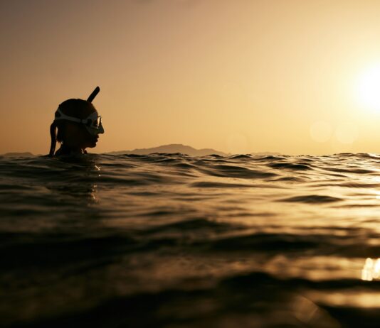 효과적인 체중관리를 위한 운동과 식습관 a person swimming in the ocean at sunset