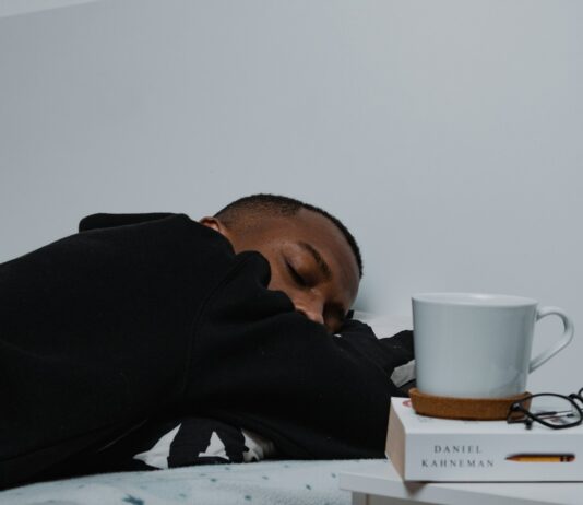 만성피로, 단순한 피로를 넘어 삶의 질을 떨어뜨린다 a man sleeping on a bed next to a stack of books