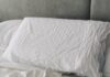 수면의 질을 높이는 한국인의 새로운 습관, 실천법은? A rumpled white duvet and pillows on a bed.