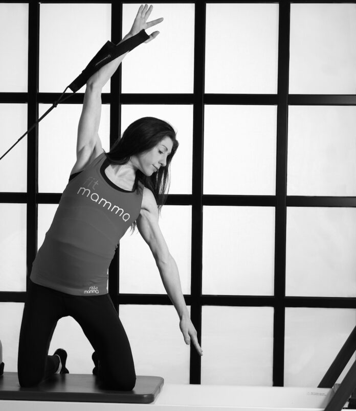 woman in white tank top and black leggings doing yoga