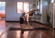 “필라테스, 바쁜 현대인의 건강 지킴이로 자리 잡다” woman in black shorts and white tank top doing yoga