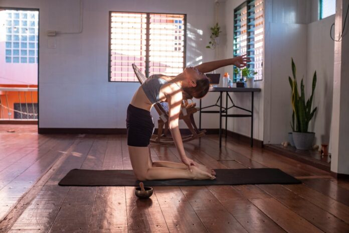 Photo by Maryjoy Caballero woman in black shorts and white tank top doing yoga